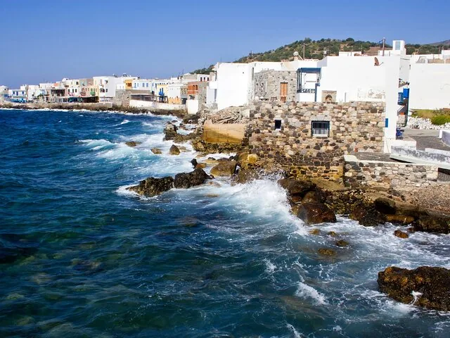 Waves crashing against the rocky shore of a coastal town