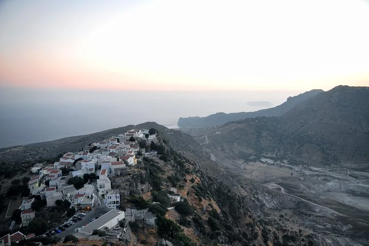 A white village on a hillside overlooking a valley and the sea
