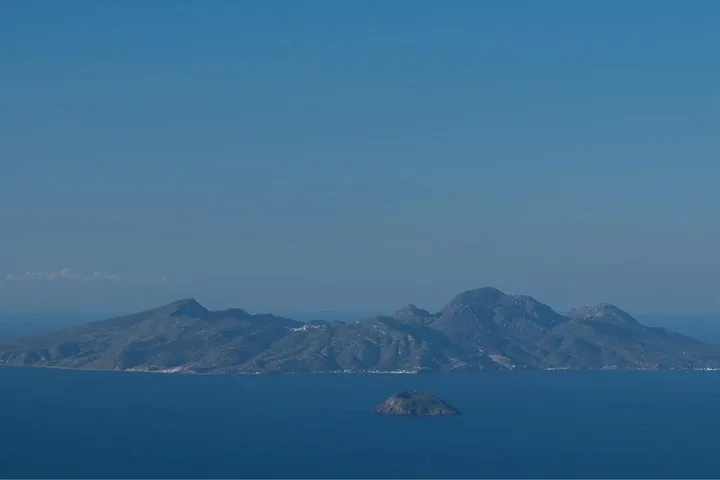 Distant view of a mountainous island surrounded by the sea