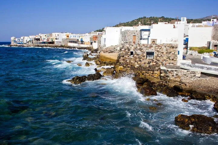 Waves crashing against the rocky shore of a coastal town
