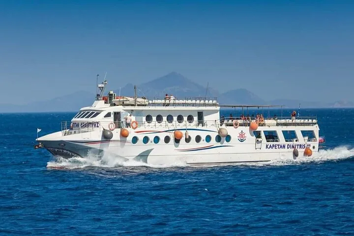 A tour boat sailing on the sea with an island in the background